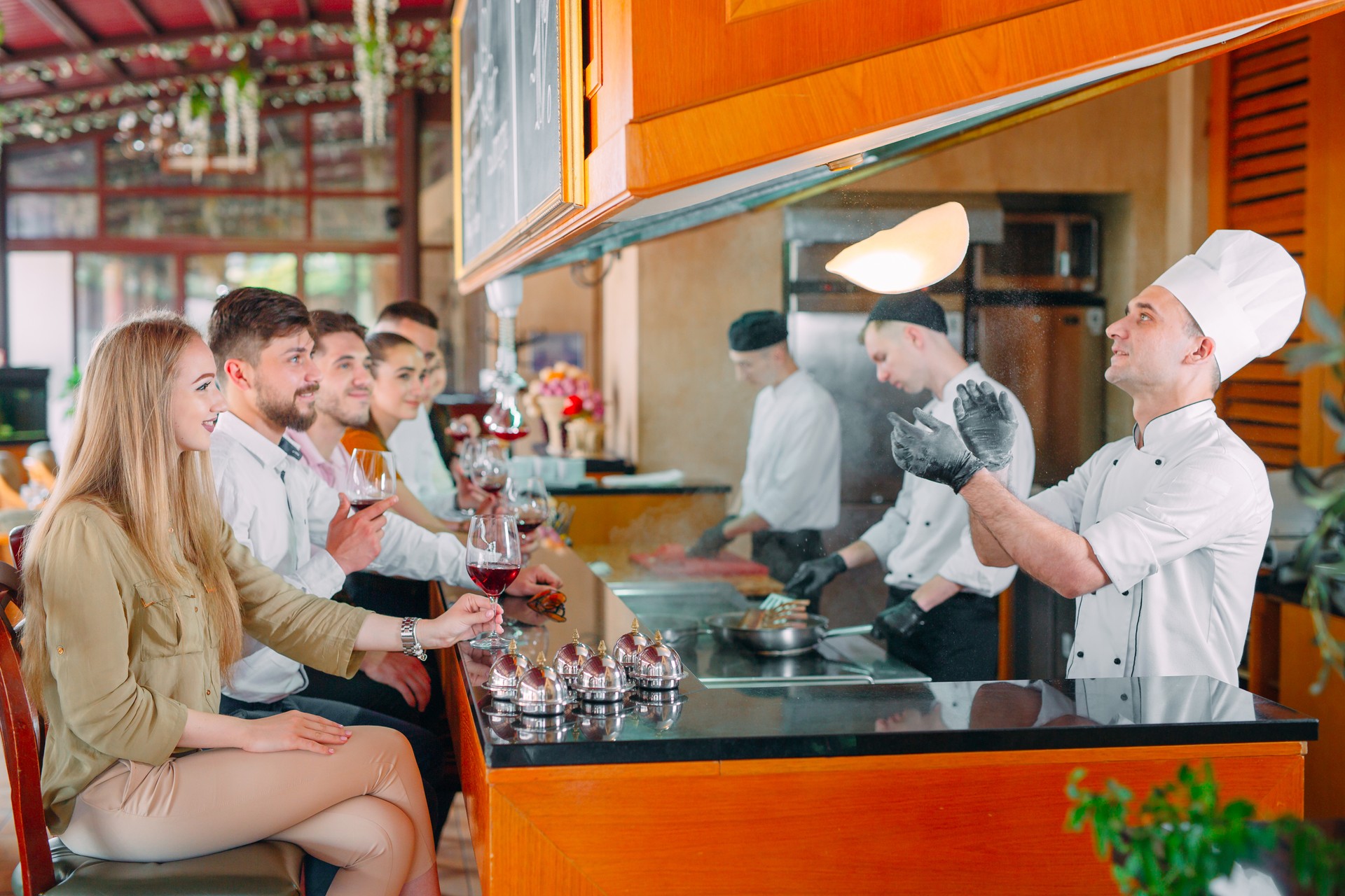 The chef prepares food in front of the visitors in the restaurant